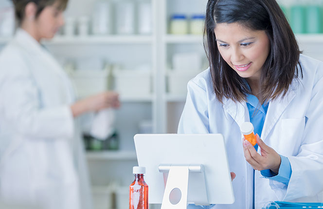 woman pharmacist checks price on prescription